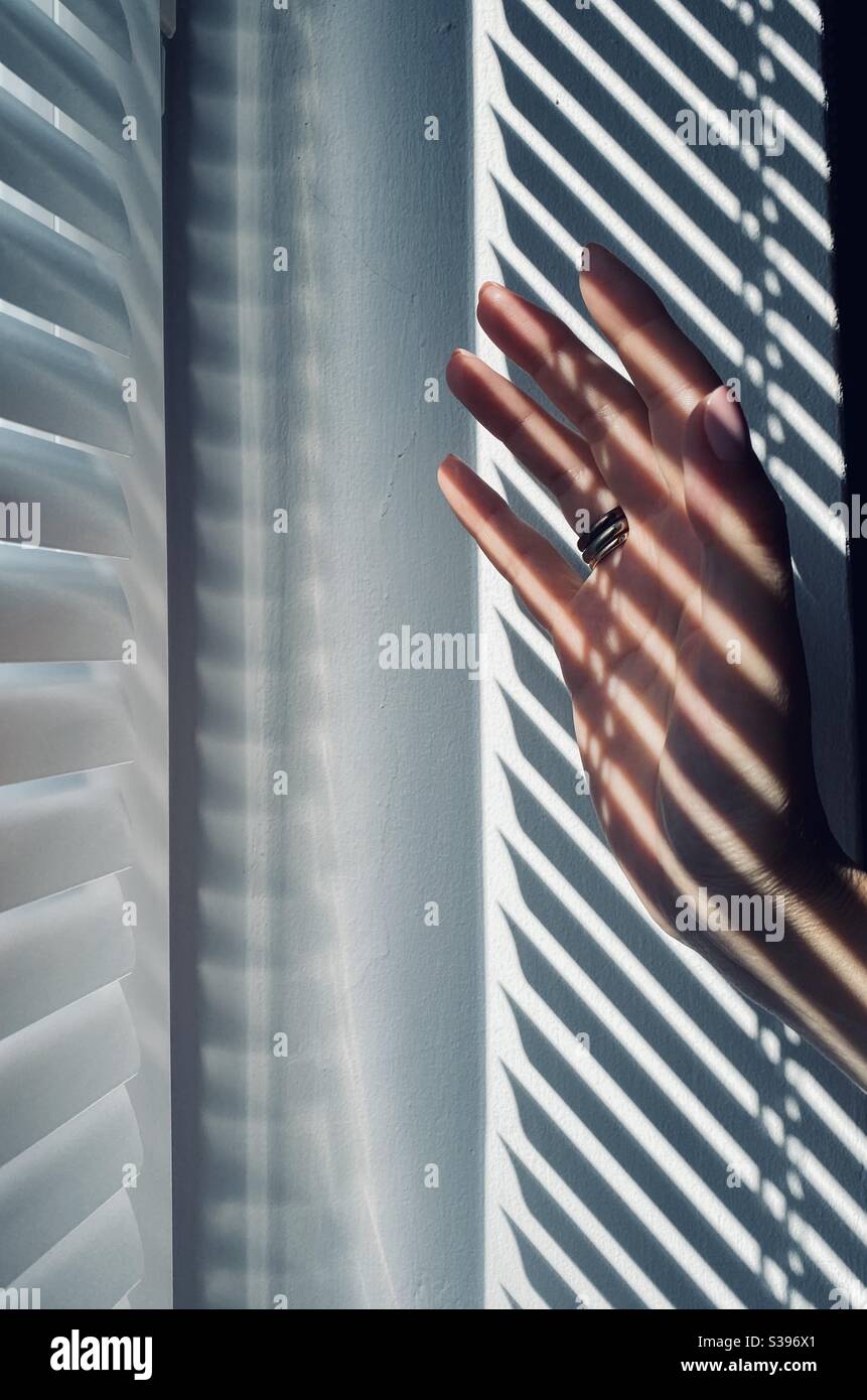 a shadow falling on the hand of a young woman Stock Photo