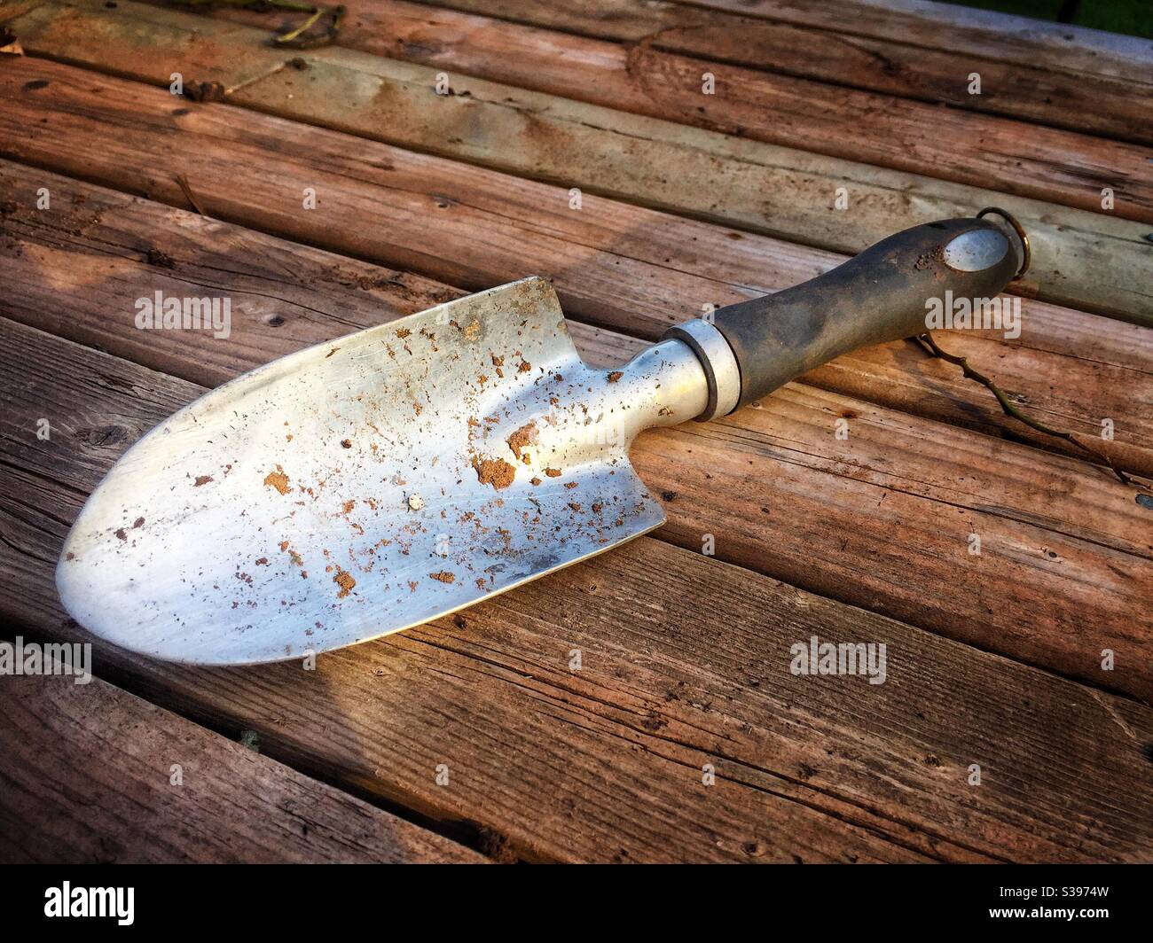Garden trowel on a wooden surface. - Smartphone Captured Stock Image