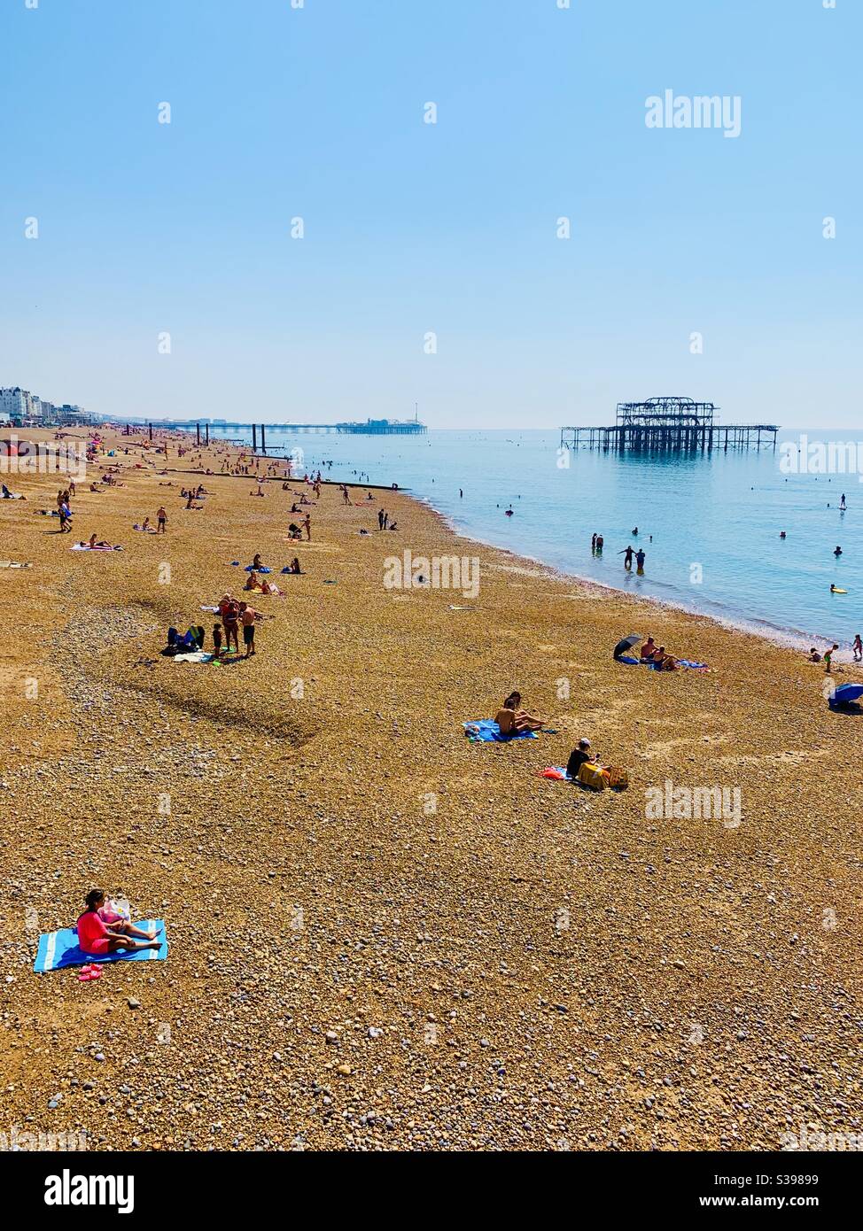 Brighton, UK - 11 August 2020: A view of both west and palace piers and the golden beach. Summer heatwave 2020. Stock Photo