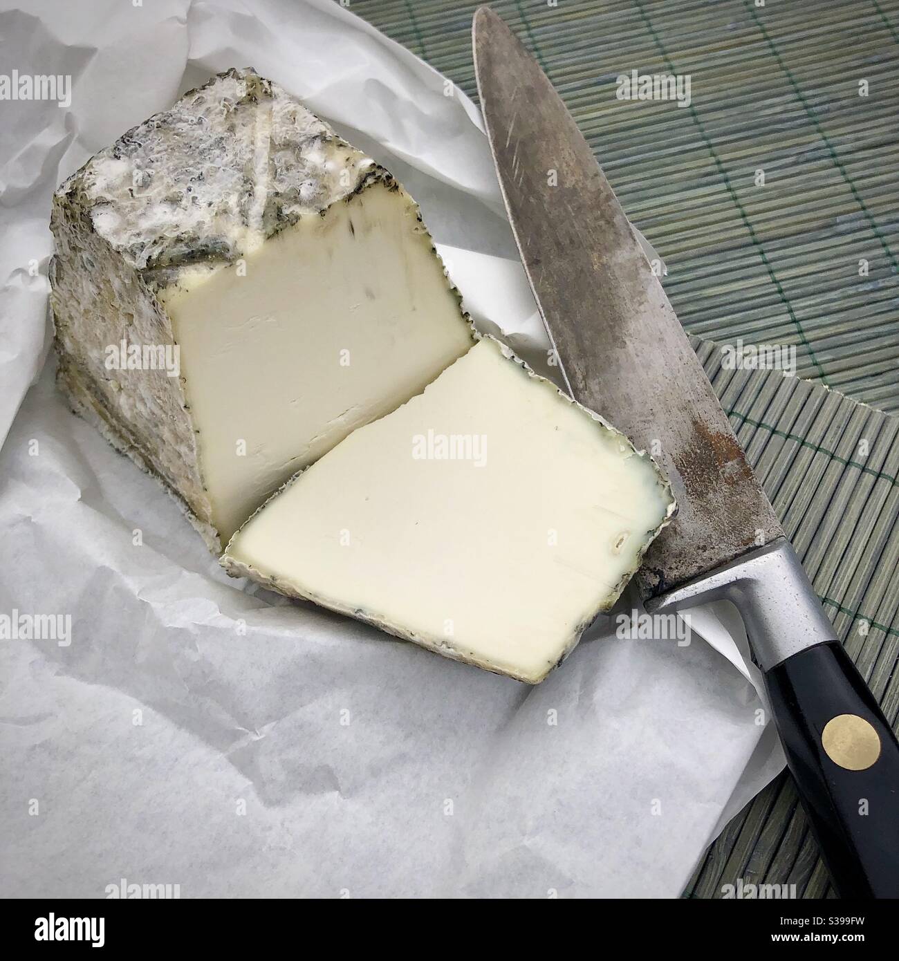 Slice of French pyramid shaped goat’s cheese. Stock Photo