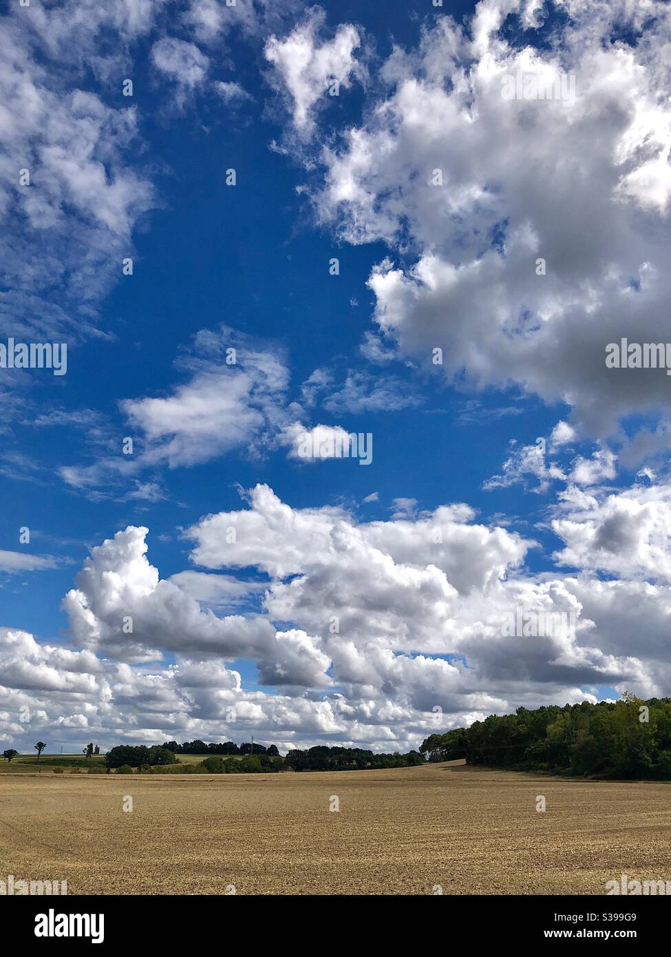 Cumulus clouds in blue sky over central France. - Smartphone Captured Stock Image