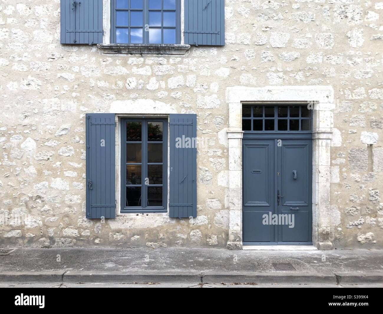 French house with gray door and window shutters - Smartphone Captured Stock Image