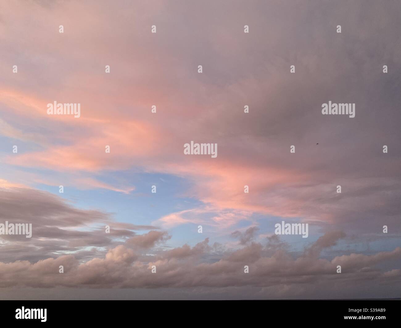 Cloudscape with sun reflecting into pink and gray clouds - Smartphone Captured Stock Image