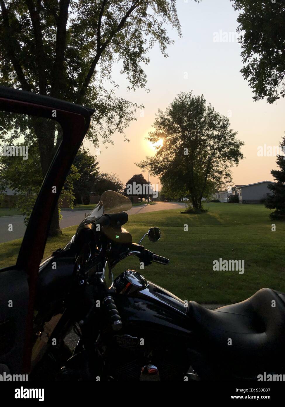 Motorcycle in front of sun settingsunsetting Stock Photo