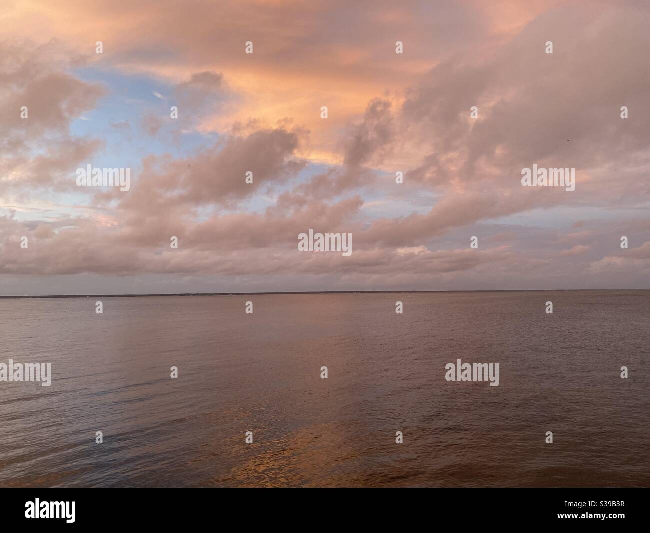 Colorful dramatic sunset skies reflecting onto bay water Stock Photo ...