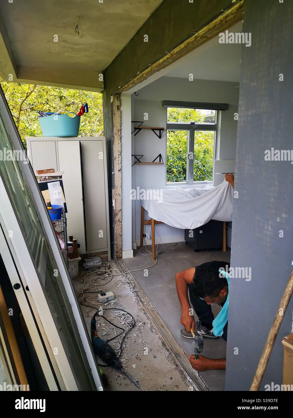 Construction workers installing a sliding window door. Stock Photo