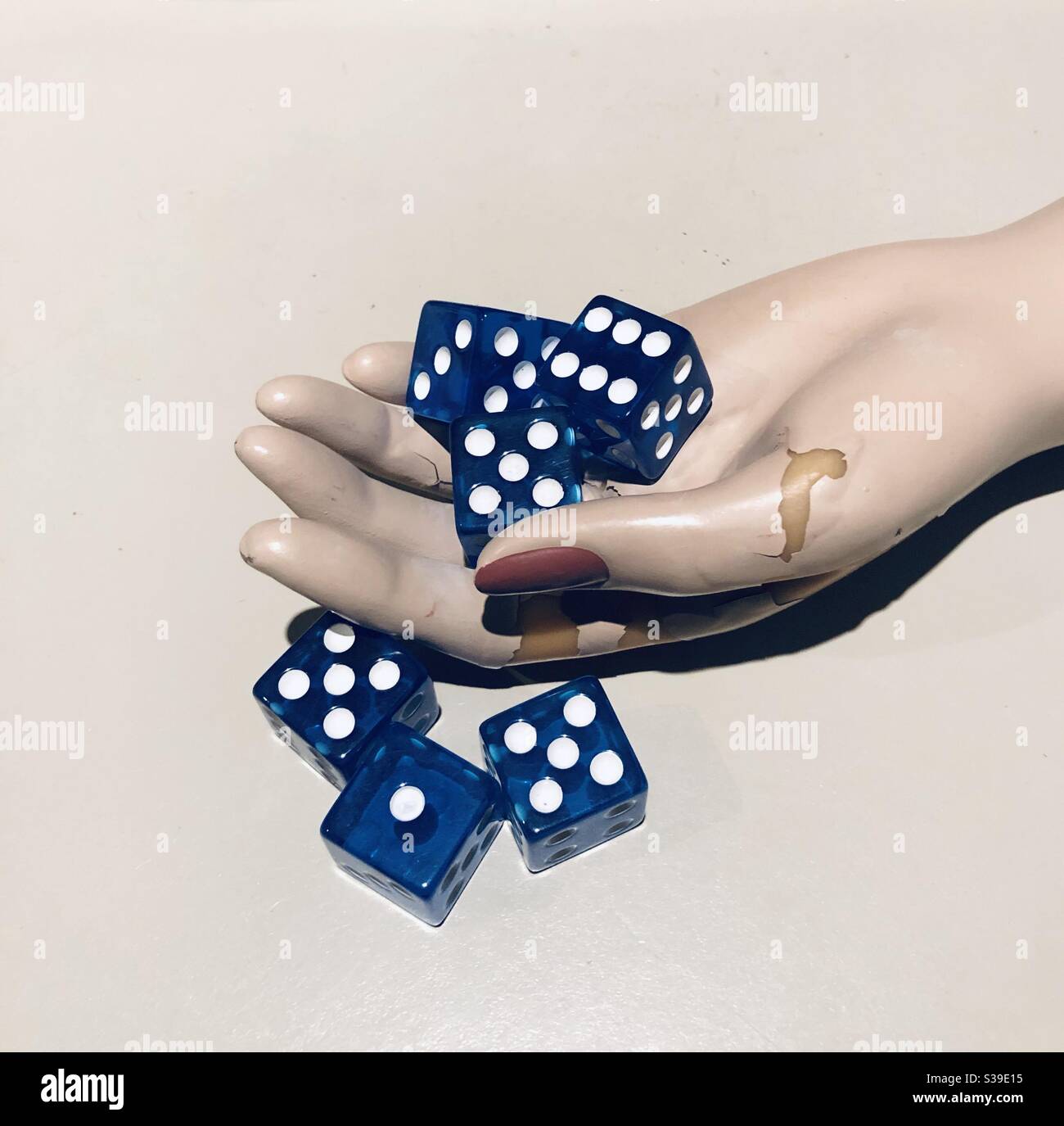 Blue dice and mannequin female hand. Concepts - Smartphone Captured Stock Image