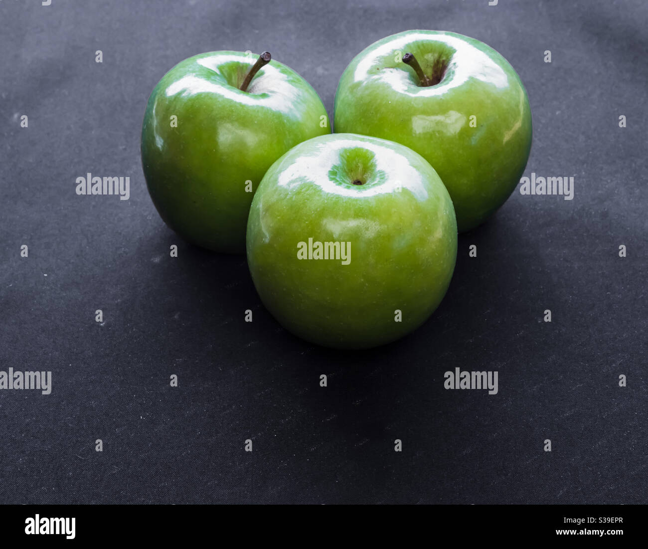 3 green apples on a black background Stock Photo