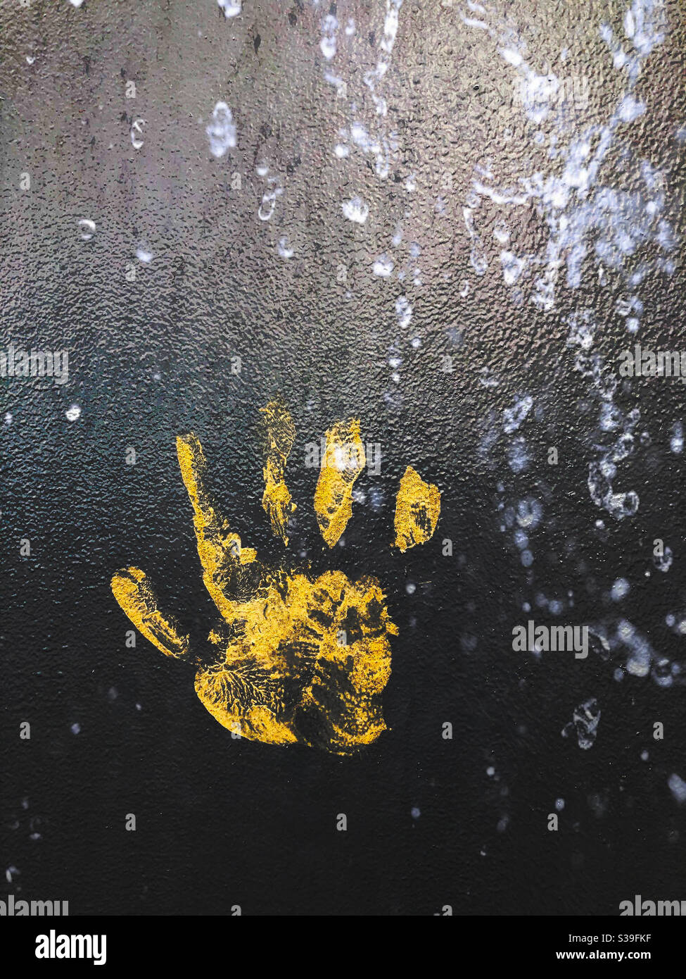 Large yellow handprint on metal background - Smartphone Captured Stock Image