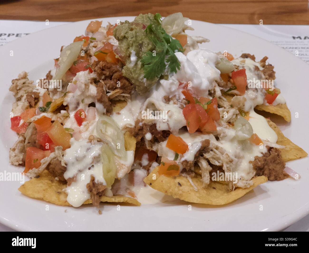 Mexican food comprising tortilla chips, guacamole, cheese and shredded chicken - Smartphone Captured Stock Image Mexican food comprising tortilla chips, guacamole, cheese and shredded chicken - Smartphone Captured Stock Image