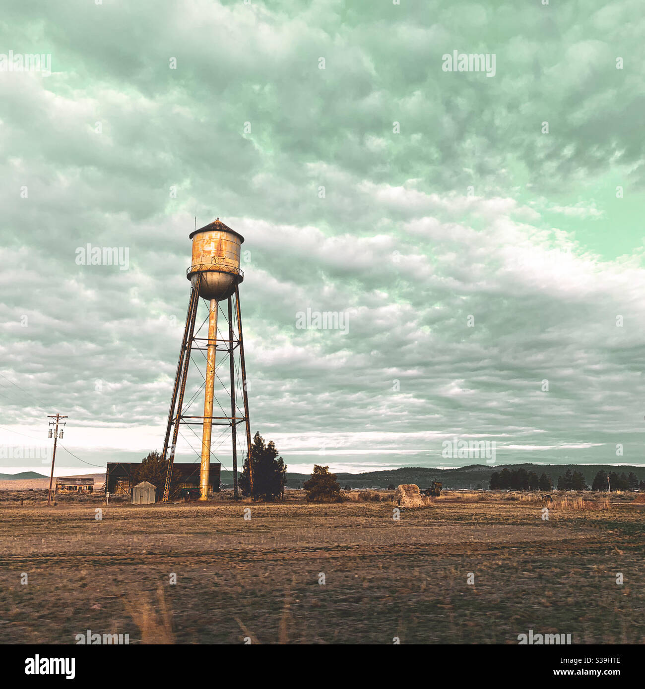 Water tower in the early morning light under a cloudy sky in California. Square crop. Stock Photo