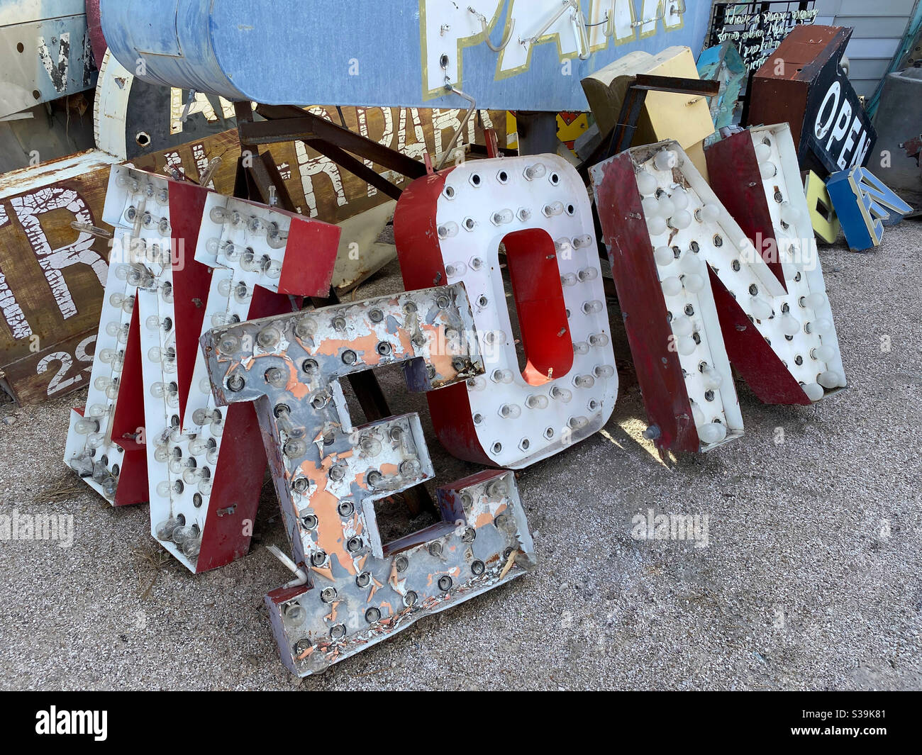 Old abandoned Neon sign among other junked signs Stock Photo