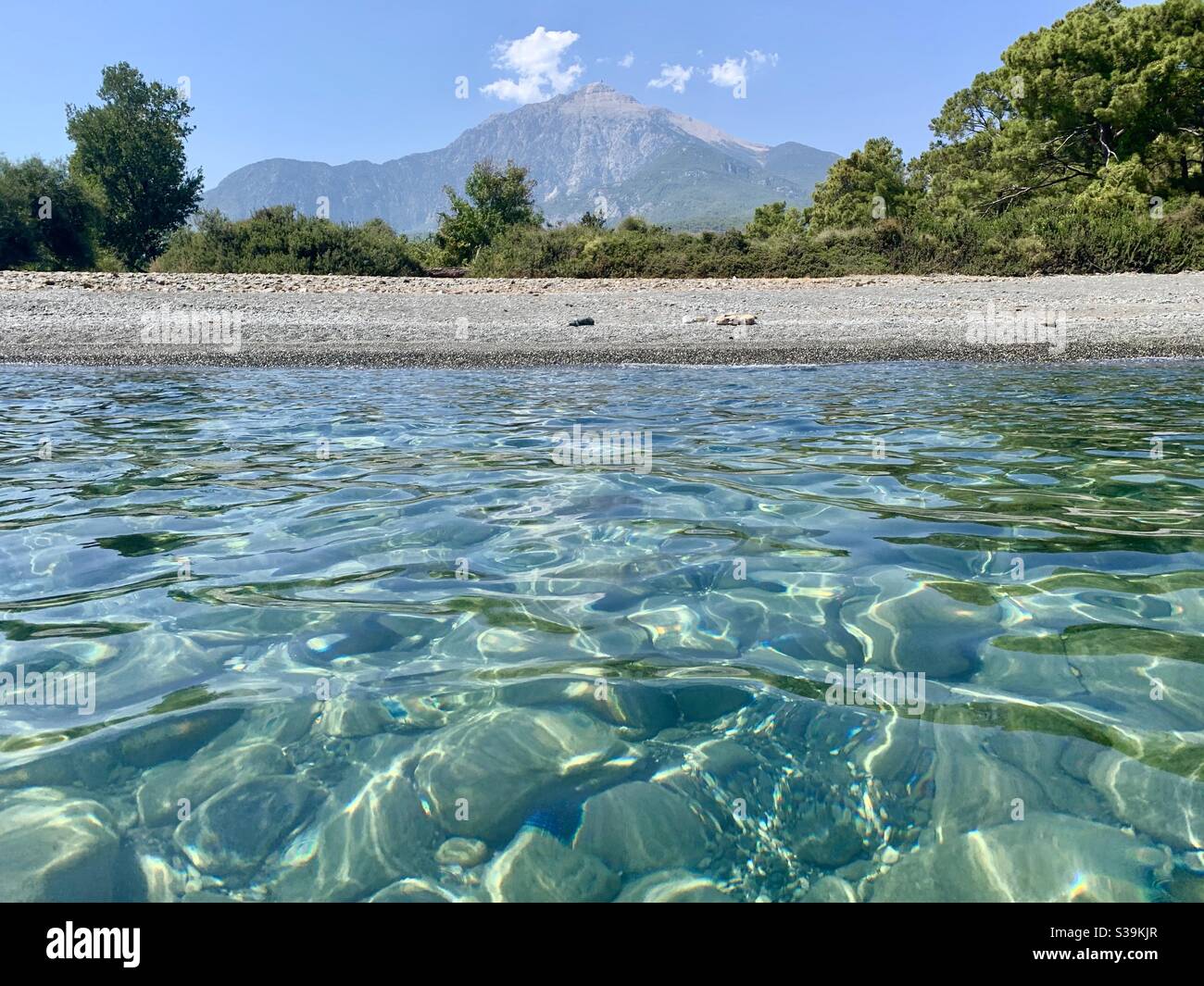 View of Tahtali mountain with crystal clear water and deserted beach - Smartphone Captured Stock Image