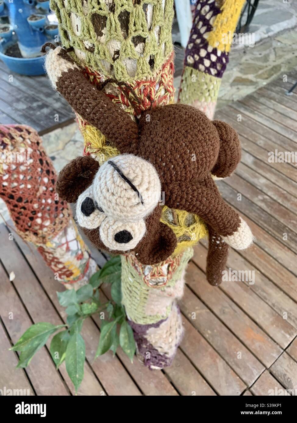Crochet monkey having fun in a crochet tree Stock Photo