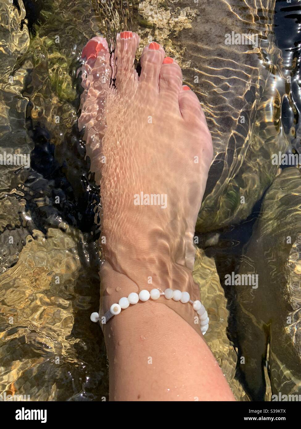 Foot in river water With pearly anklet Stock Photo