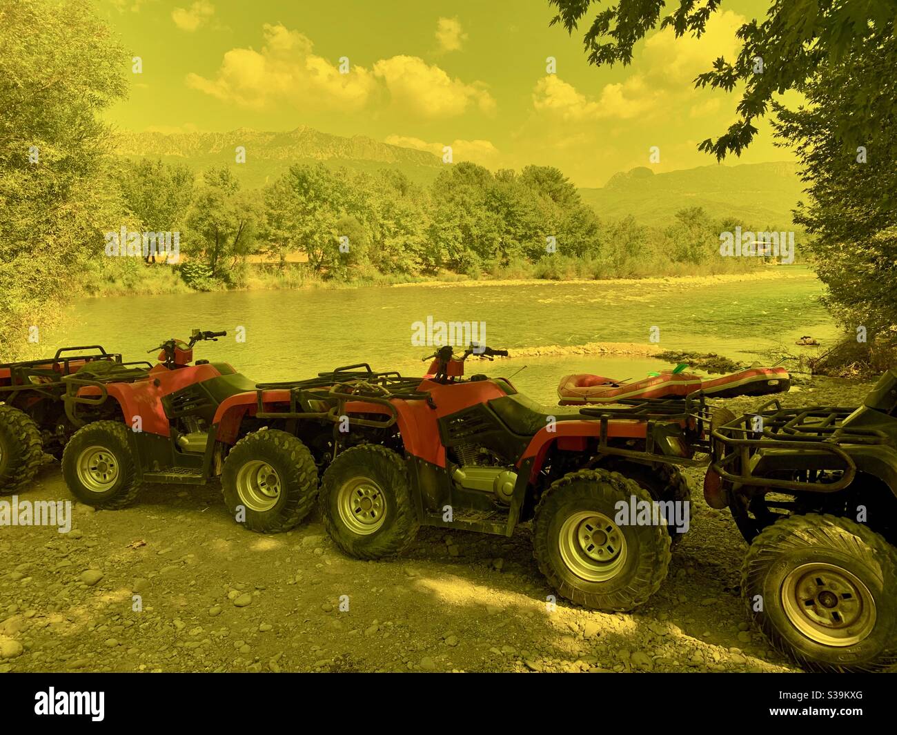 Quad bikes parked along river bank with yelp filter from protective glasses - Smartphone Captured Stock Image