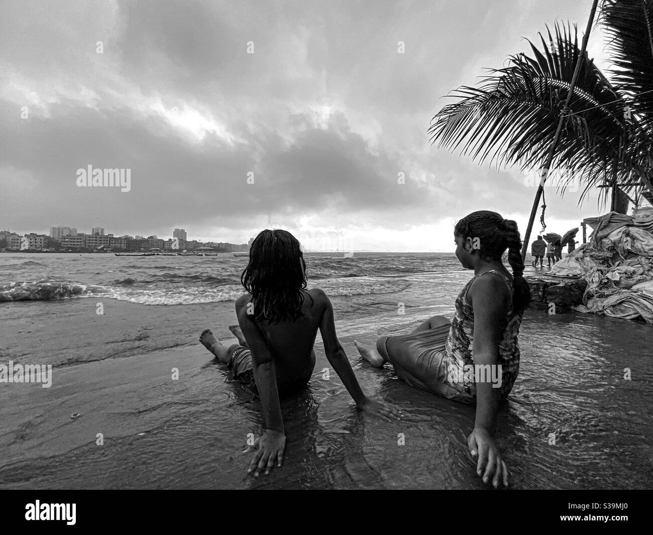 Kids enjoying high tide during monsoon in mumbai. Stock Photo