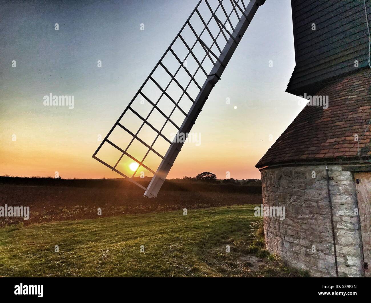The sun setting through the sail of Stevington Windmill in Bedfordshire - Smartphone Captured Stock Image