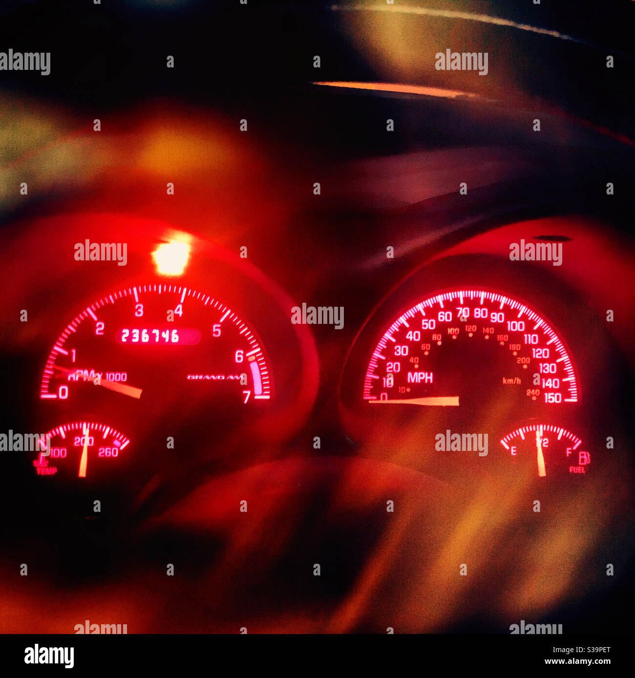 The dash of a 2004 Pontiac Grand Am is lit at night, with motion blurs and light leaks to give the feeling of night driving. (Photo by Carmen K. Sisson/Cloudybright) Stock Photo