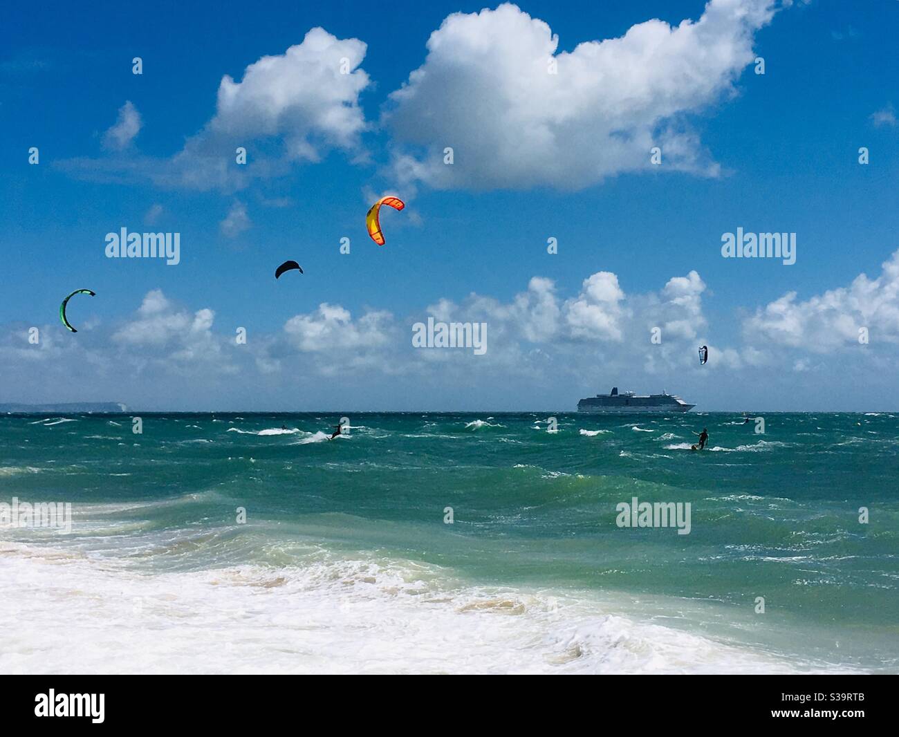 Kite surfers and a cruise liner off Bournemouth beach with the Isle of Wight in the background Stock Photo