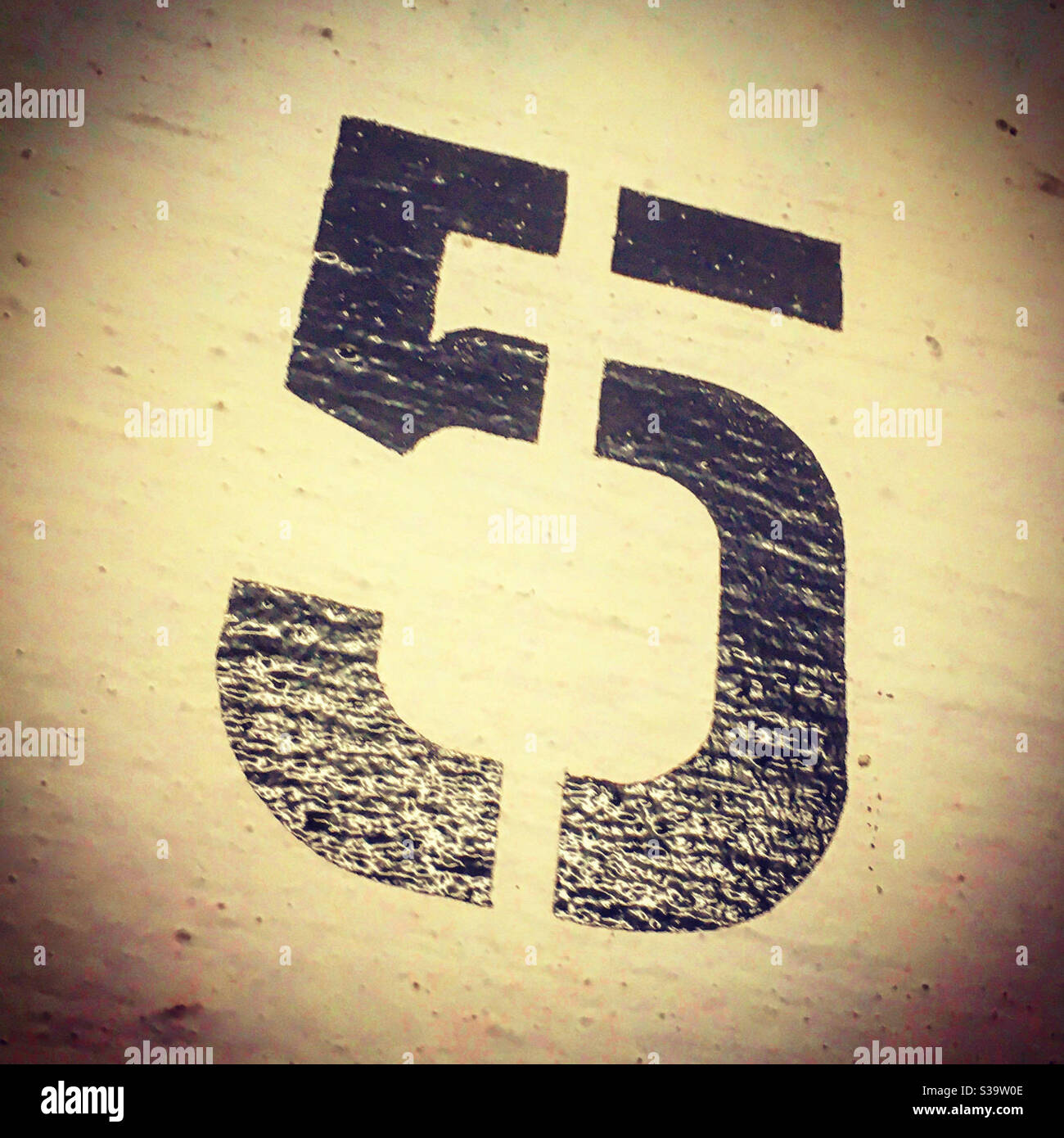 number 5 painted in black color on a white wall in a stencil way Stock Photo