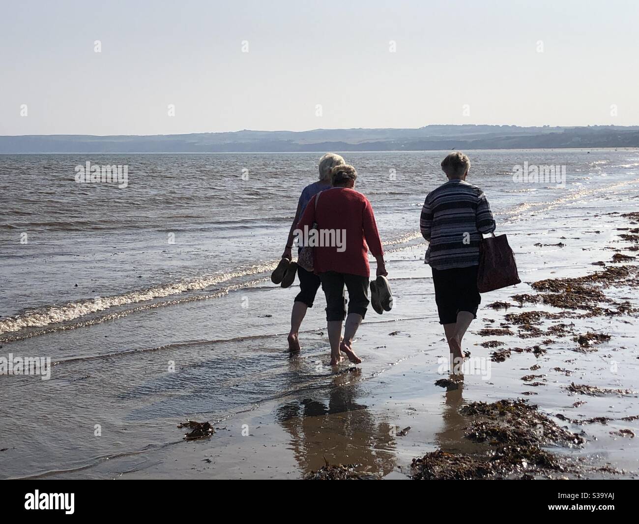 Ladies enjoying a paddle in the sea on the last day of summer - Smartphone Captured Stock Image