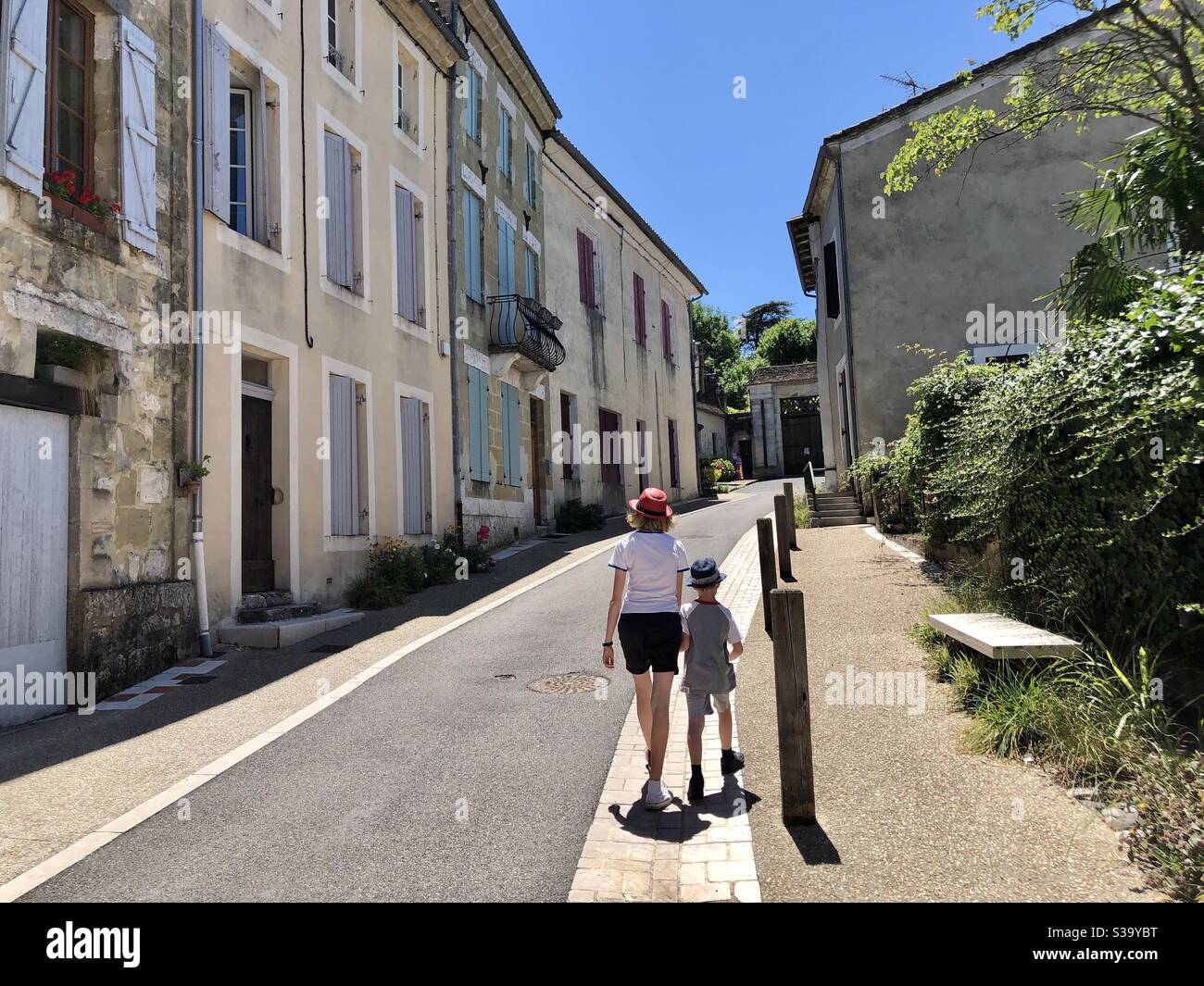 Two children walking down the street in the French town of Lauzun Stock Photo