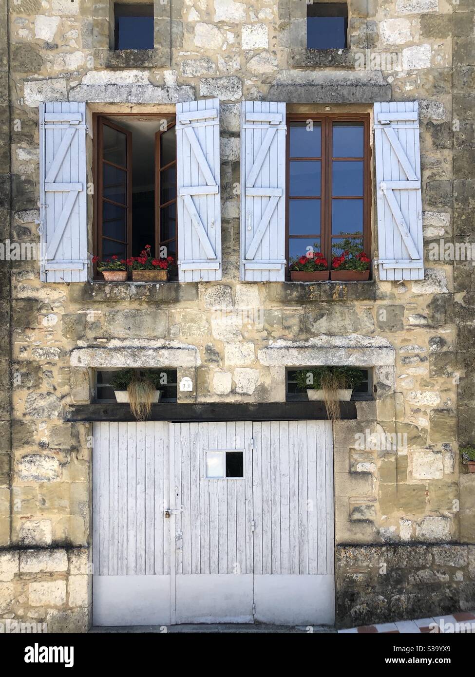 Old stone built house with white painted door and window shutters - Smartphone Captured Stock Image