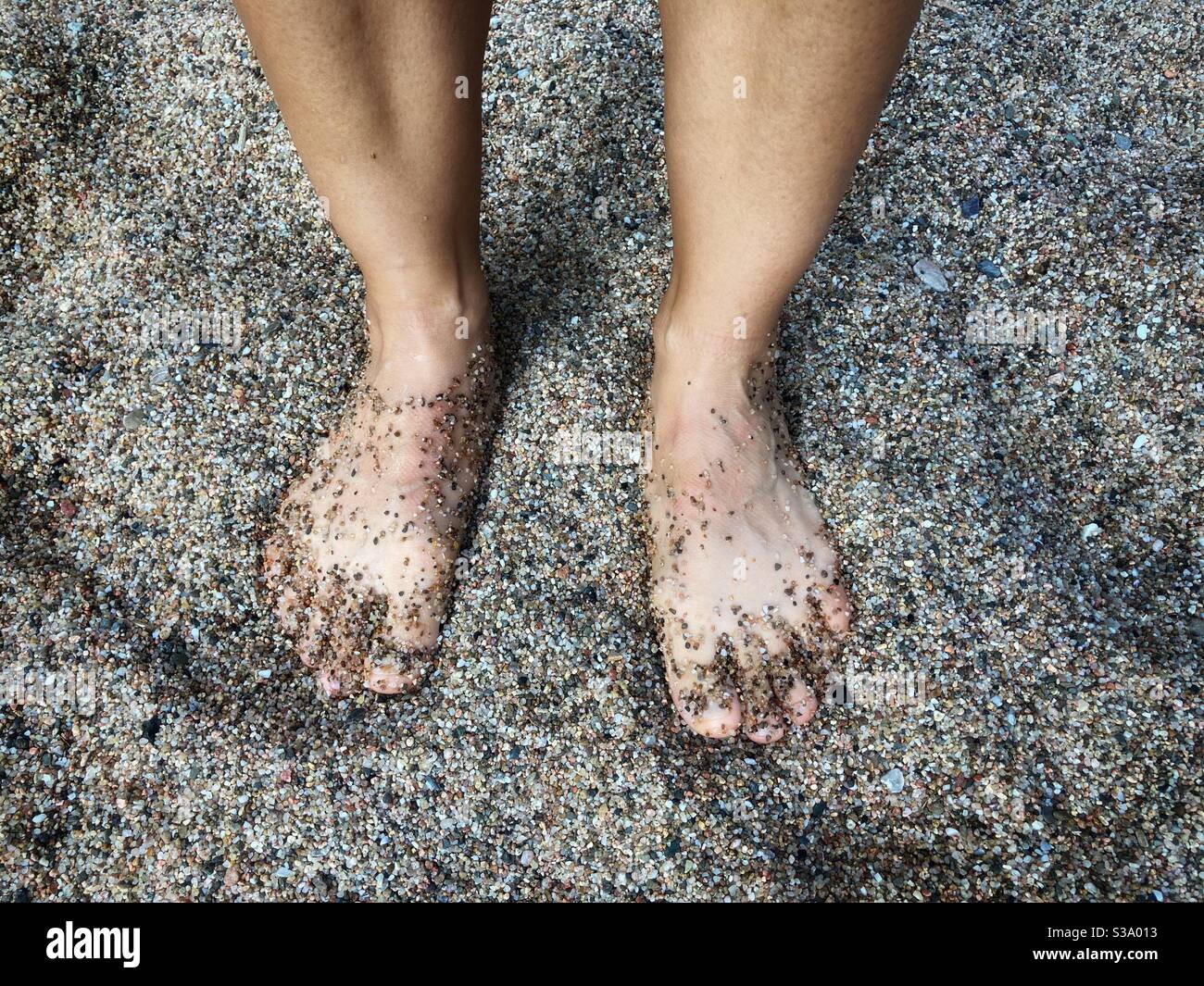 Feet on sand, elevated view Stock Photo