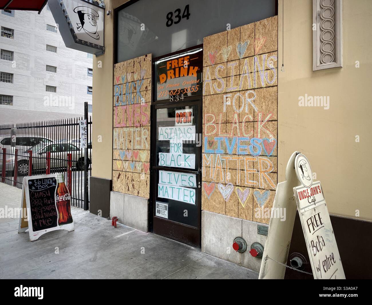 LOS ANGELES, CA, JUN 2, 2020: boarded up windows and signage at Asian-run Uncle John's Cafe in Downtown during Covid-19 pandemic and between Black Lives Matter protest marches - Smartphone Captured Stock Image