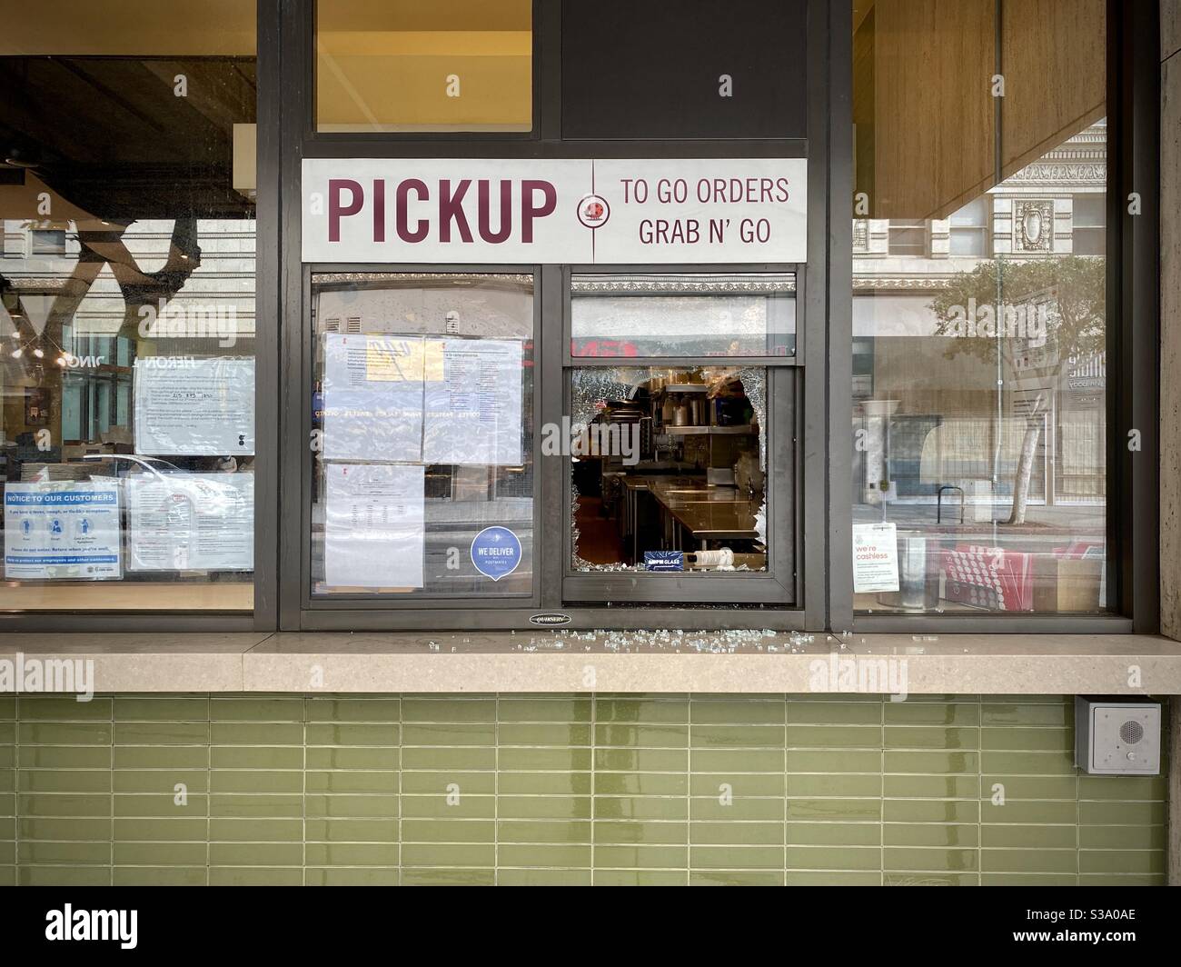 LOS ANGELES, CA, MAY 30, 2020: smashed window at the pickup counter of a restaurant in Downtown, morning after riots and political protests - Smartphone Captured Stock Image