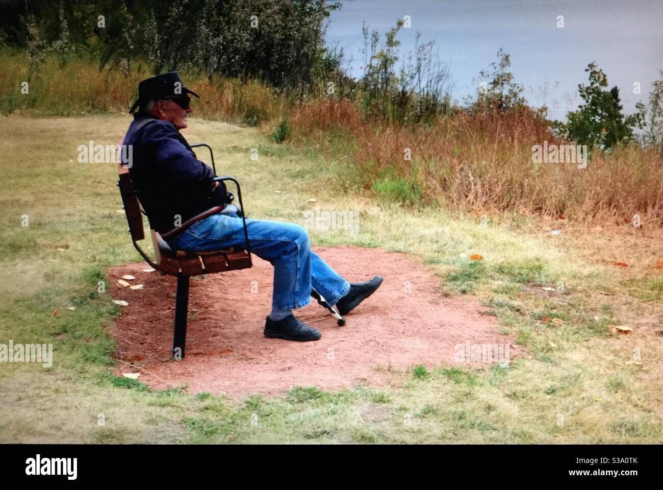 Elderly man, resting, North Glenmore Park, Calgary, Alberta, autumn, Glenmore reservoir,park bench, cane, leather hat - Smartphone Captured Stock Image
