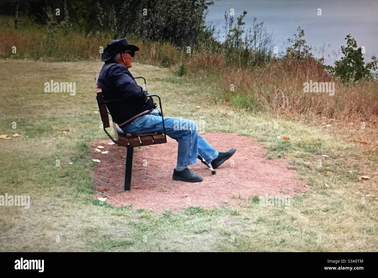 Elderly man, resting, North Glenmore Park, Calgary, Alberta, autumn, Glenmore reservoir,park bench, cane, leather hat - Smartphone Captured Stock Image