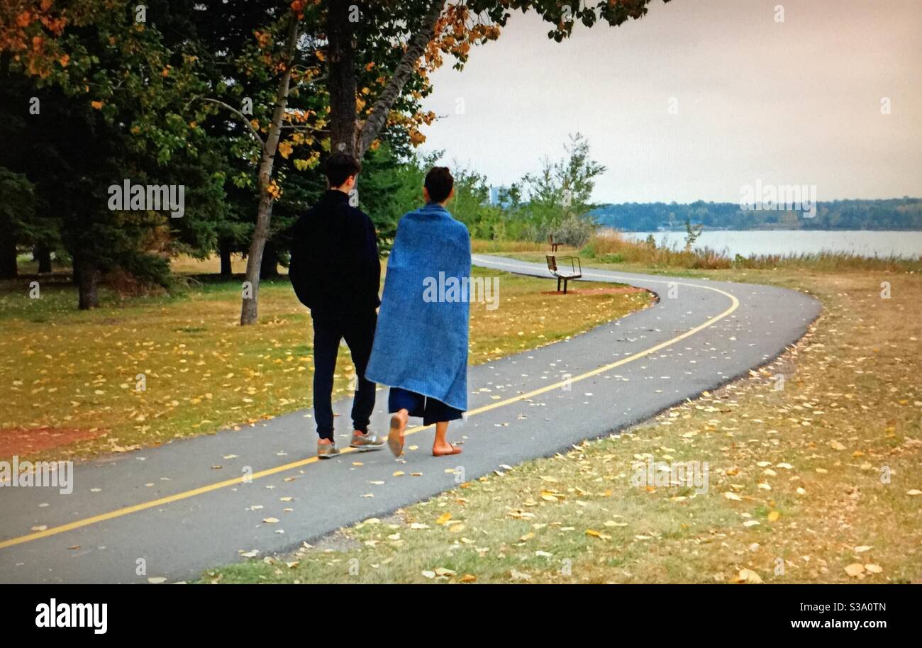 Couple walking,man, woman,North Glenmore Park, Calgary, Alberta, autumn, Glenmore reservoir,park - Smartphone Captured Stock Image