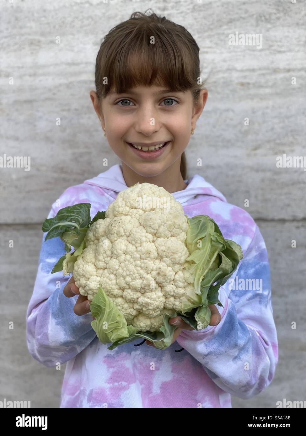 Happy young girl showing a bio cauliflower Stock Photo Alamy