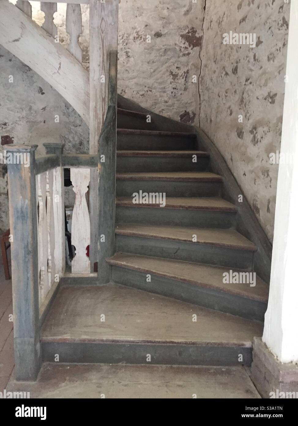 Shabby wooden stairway in blue, white and brown leading to a gallery in a church Stock Photo