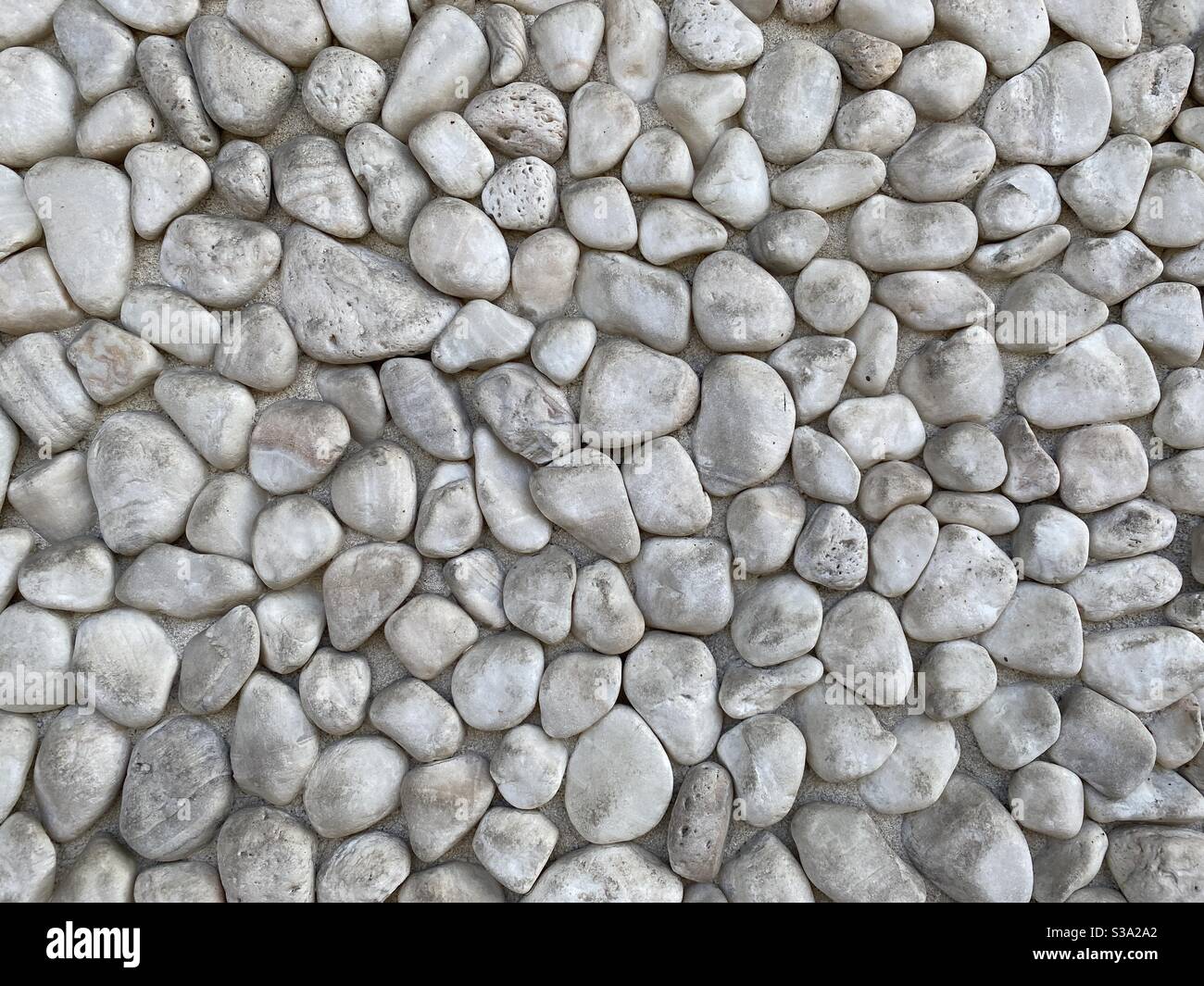 Abstract background texture created by small, light-colored pebbles - Smartphone Captured Stock Image