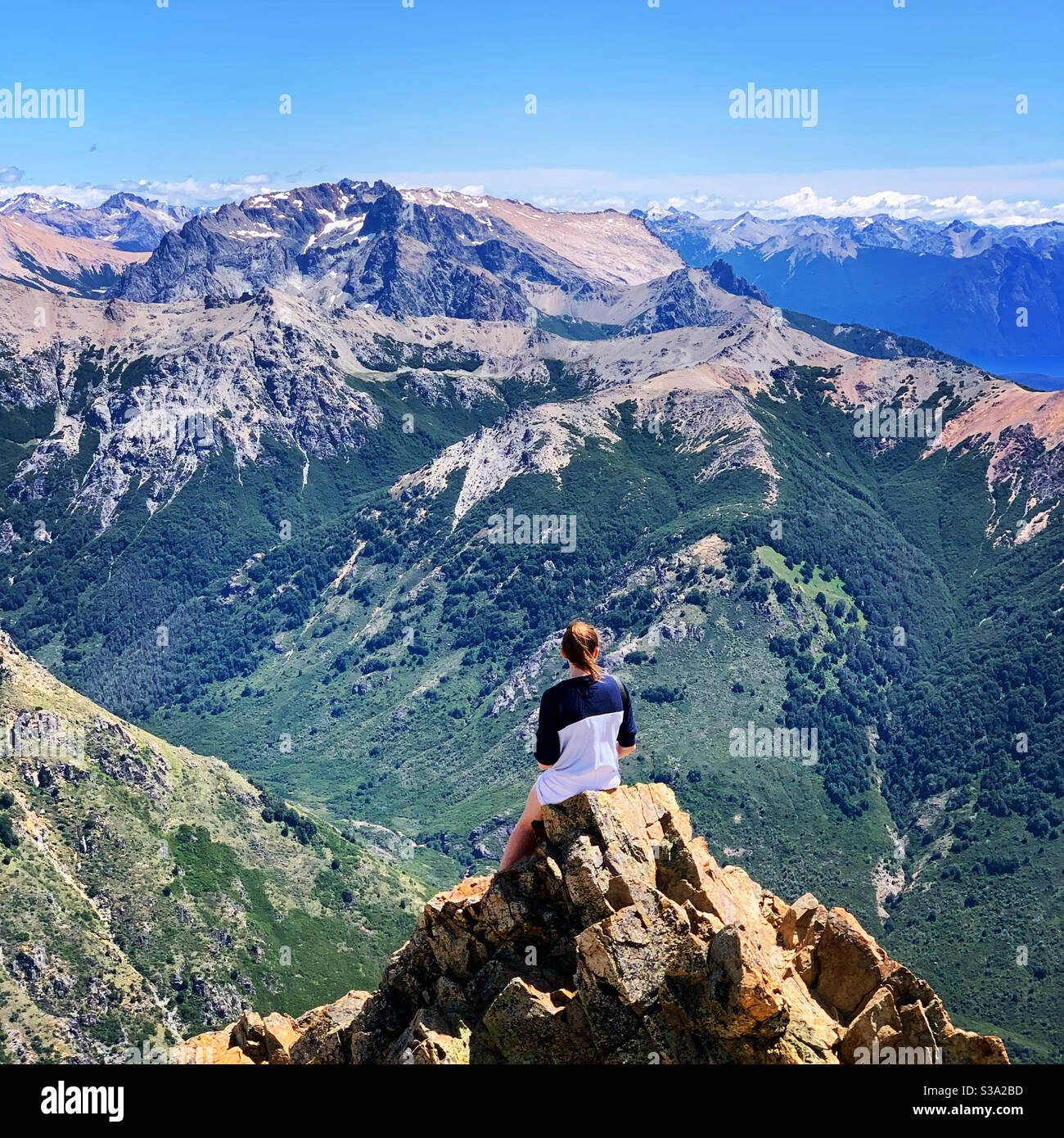 Girl Looking Over Rocks Woman looking out from a rock over the Andes mountains Stock Photo - Alamy