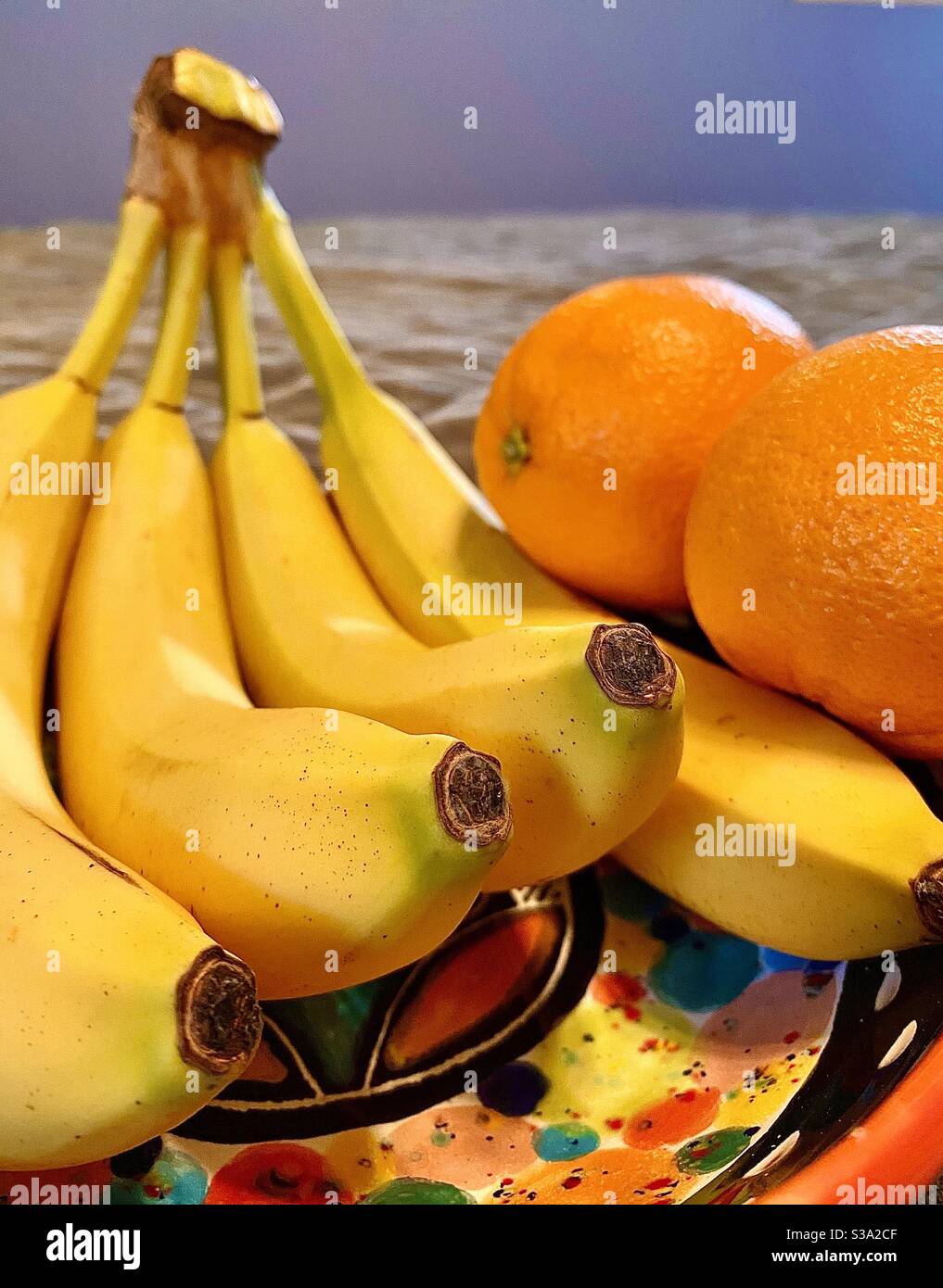 Close up of bananas and oranges in colorful bowl Stock Photo Alamy