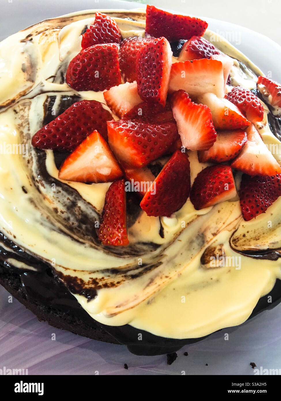 Sweet Food, strawberries piled on top of A chocolate cake swirled with chocolate ganache and cream, yum! Treat yourself - Smartphone Captured Stock Image