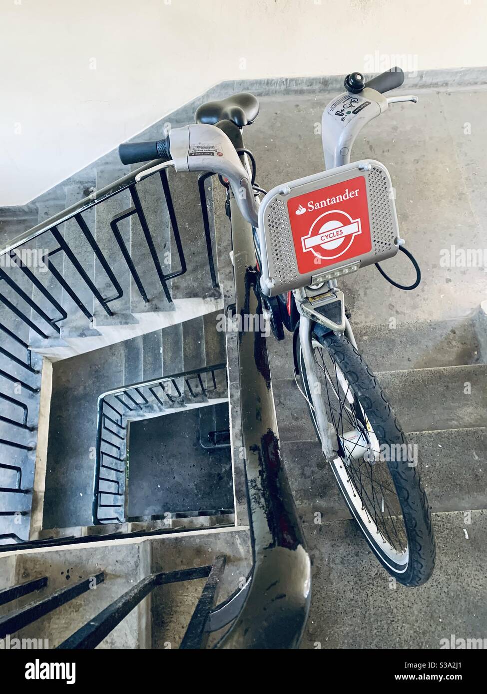 Boris bike locked to railings in council block Stock Photo