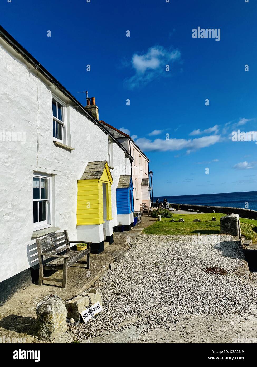 Fisherman’s cottages @ Charlestown Cornwall blue  sea and sky ..ancient cottages yellow and blue painted doors - Smartphone Captured Stock Image