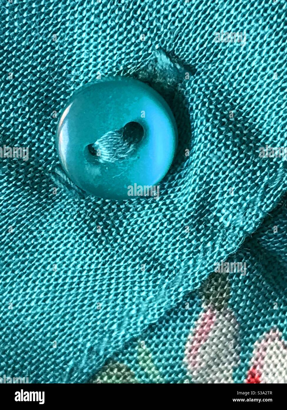 Button in blue fabric. - Smartphone Captured Stock Image