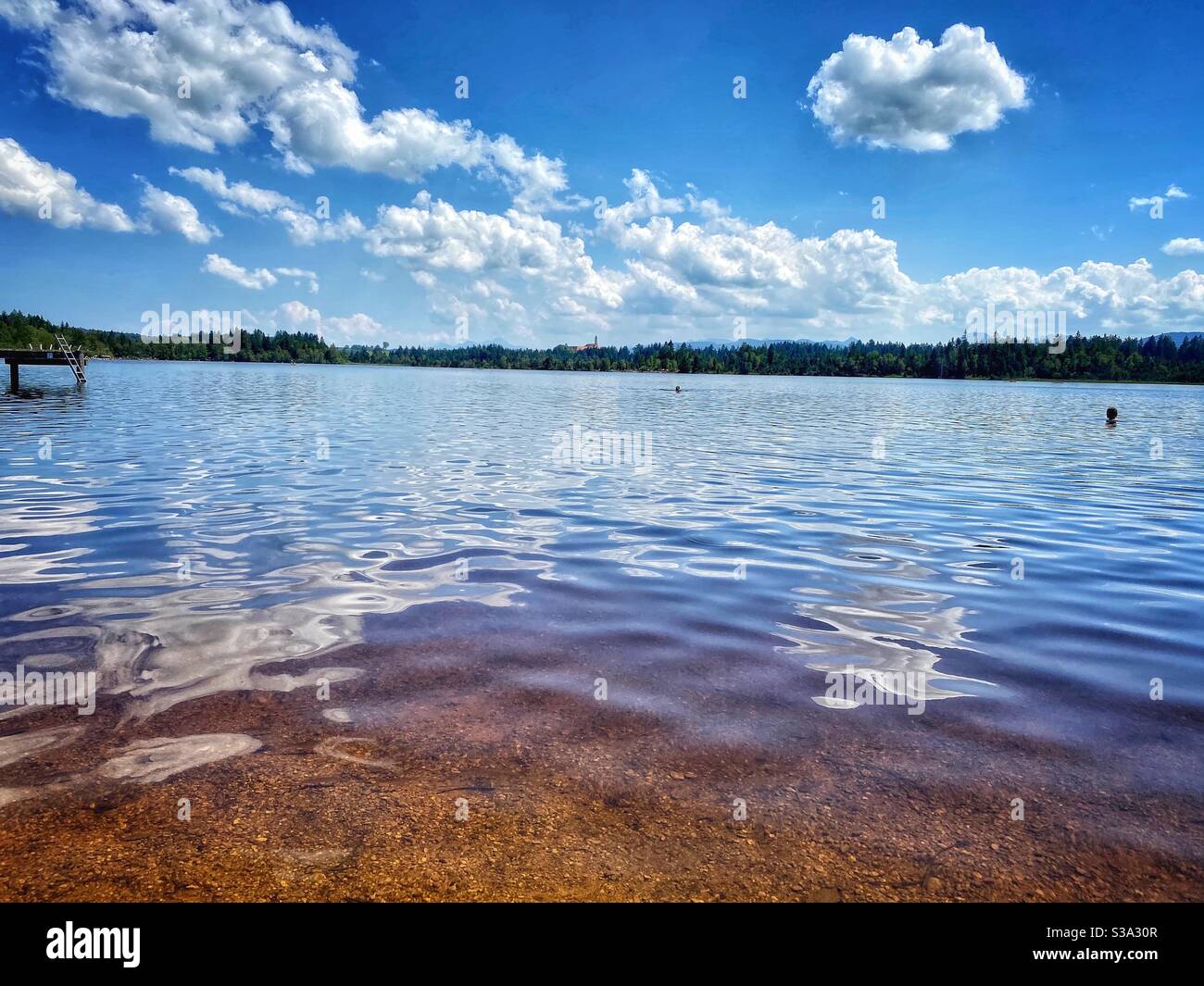 Brown moor waters and cloud reflections at lake Kirchsee in South Germany. - Smartphone Captured Stock Image