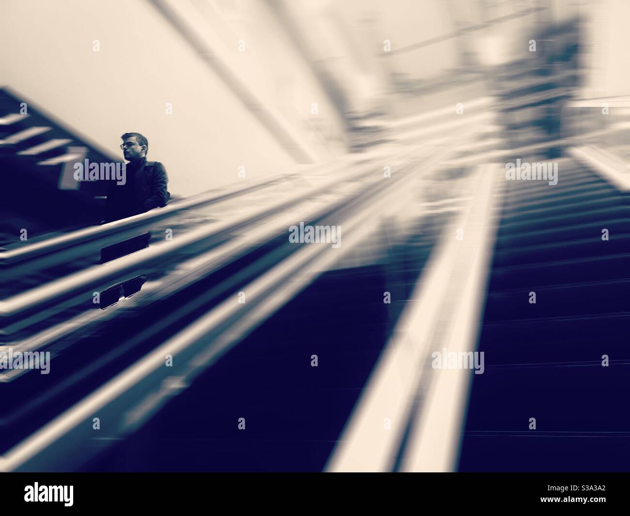 Going down - Man descending escalator - Smartphone Captured Stock Image