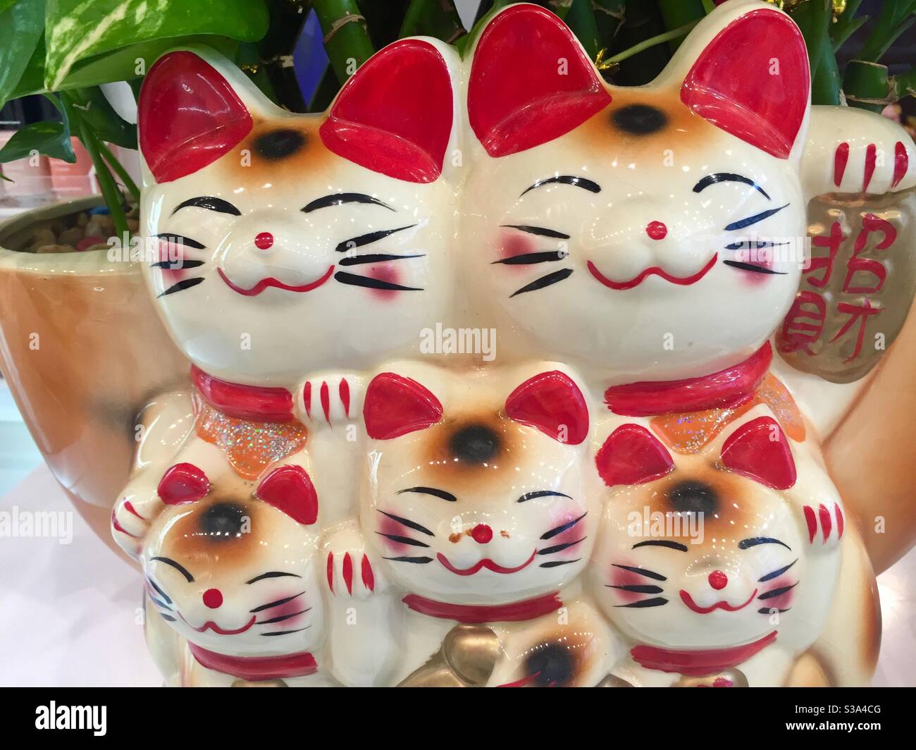 Porcelain set of five Maneki Neko greeting cat figures - Smartphone Captured Stock Image