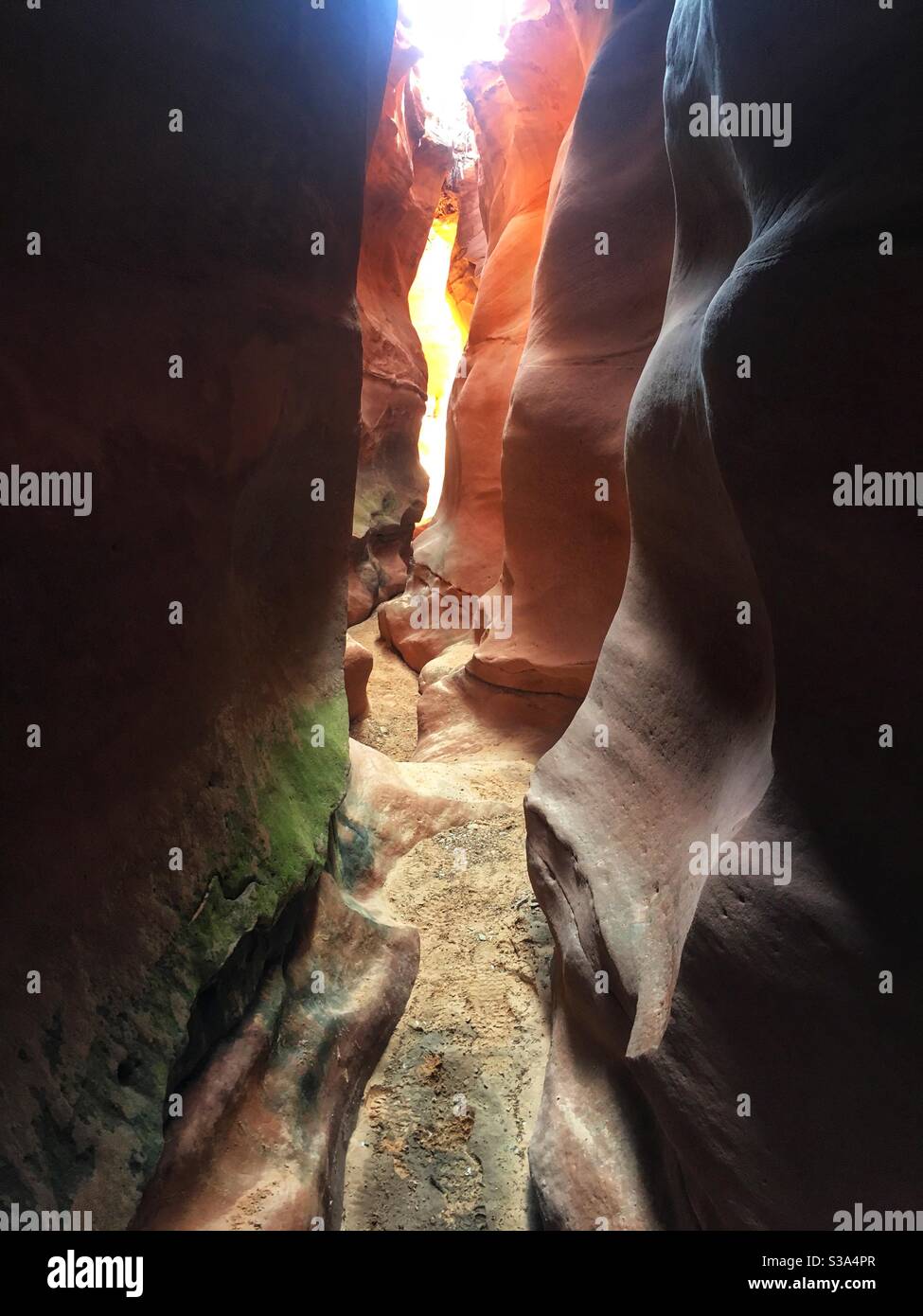 Hiking through a desert slot canyon in red rock country in southern Utah. Stock Photo