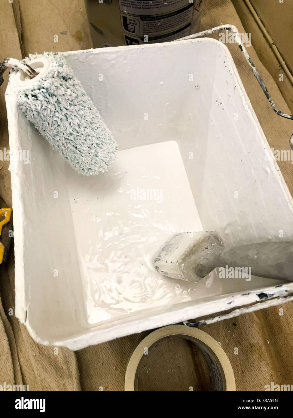 Paint brush and roller in a container of paint. - Smartphone Captured Stock Image