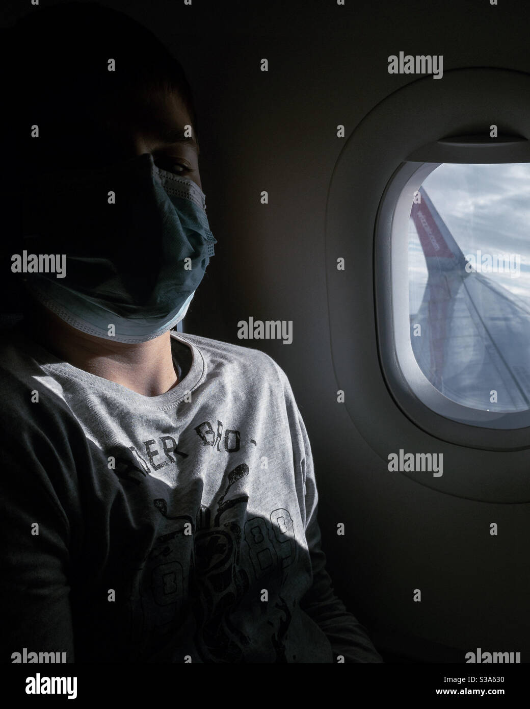 Passenger with a face COVID mask on an airliner plane Stock Photo
