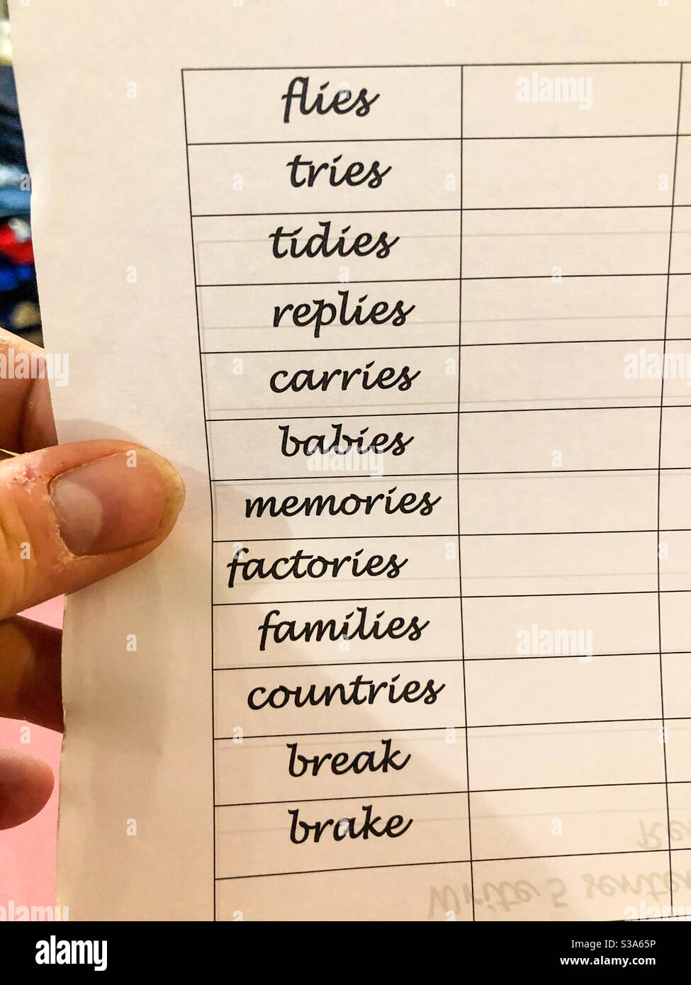 A parent holding a lost of spelling his child needs to learn. - Smartphone Captured Stock Image